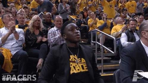 A Man In A Pacers Shirt Sits In The Stands Watching A Game GIF