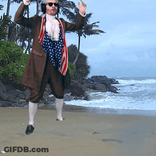 A Man In A Patriotic Outfit Is Standing On A Beach GIF