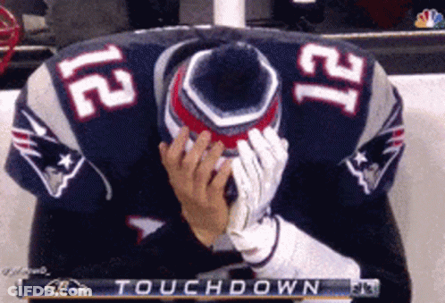 A Man In A Patriots Jersey Is Covering His Face During A Touchdown GIF