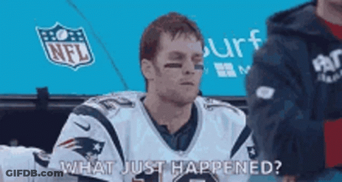 A Man In A Patriots Jersey Is Sitting In The Stands And Talking To Someone . GIF