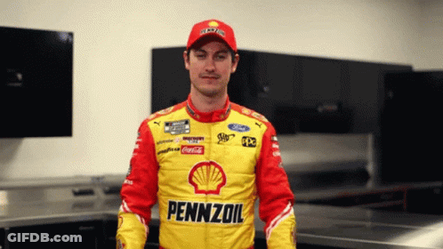 A Man In A Pennzoil Jacket Stands In A Room GIF