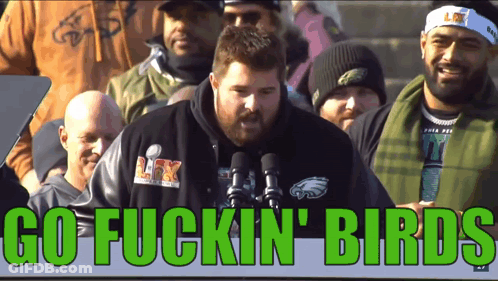 A Man In A Philadelphia Eagles Shirt Stands In Front Of A Microphone With The Words Go Fuckin Birds Above Him GIF