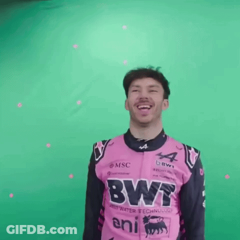 A Man In A Pink And Black Racing Suit Is Laughing And Smiling . GIF