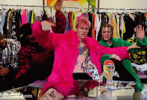 A Man In A Pink Fur Coat Is Sitting On A Table With Other People GIF
