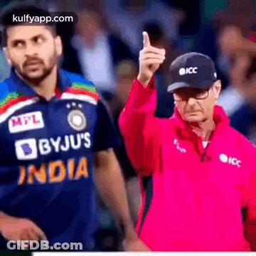 A Man In A Pink Jacket Is Giving A Thumbs Up While A Man In A Blue Shirt Is Standing Behind Him . GIF