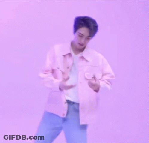 A Man In A Pink Jacket Is Making A Heart With His Hands GIF