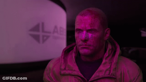 A Man In A Pink Jacket Is Standing In Front Of A Lab Sign GIF