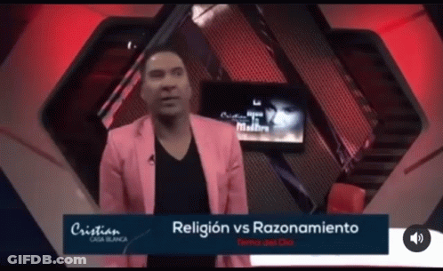 A Man In A Pink Jacket Stands In Front Of A Screen That Says Religion Vs Razonamiento GIF