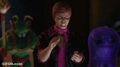 A Man In A Pink Scarf Stands In Front Of A Purple Monster GIF
