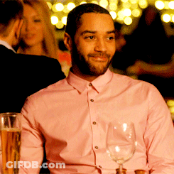 A Man In A Pink Shirt Holds A Wine Glass GIF