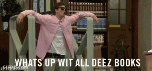 A Man In A Pink Shirt Is Dancing In A Library With The Words Whats Up Wit All Deez Books Behind Him . GIF