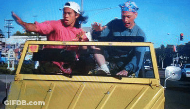 A Man In A Pink Shirt Is Driving A Yellow Car GIF