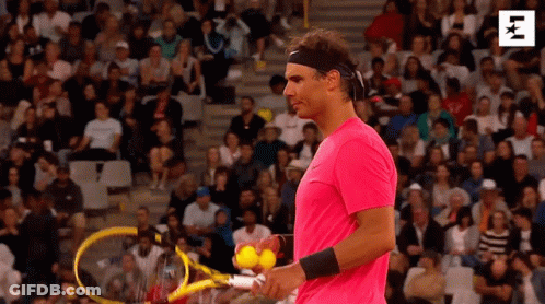 A Man In A Pink Shirt Is Holding A Tennis Racket And Balls . GIF