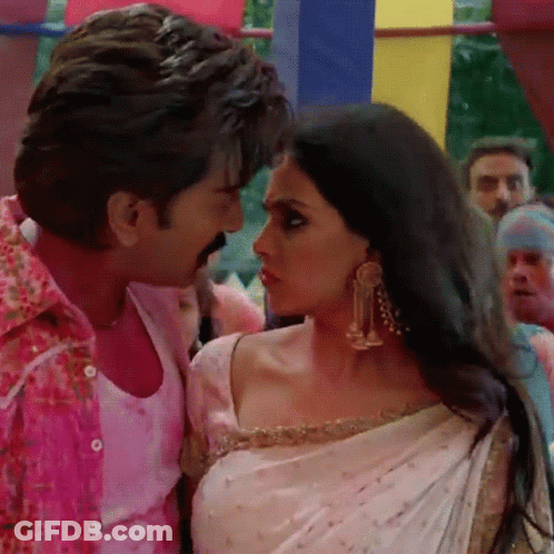 A Man In A Pink Shirt Is Kissing A Woman In A White Sari GIF