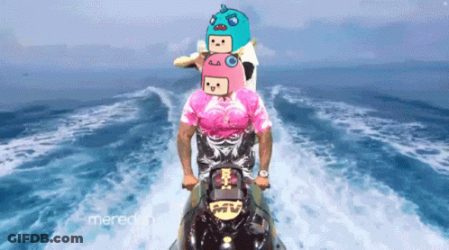 A Man In A Pink Shirt Is Riding A Jet Ski With A Cartoon Face On His Head GIF