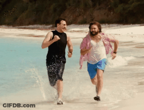 A Man In A Pink Shirt Is Running On The Beach With Another Man GIF