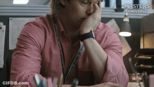 A Man In A Pink Shirt Is Sitting At A Desk With Masters Of The Universe Written On The Bottom GIF