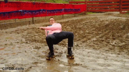A Man In A Pink Shirt Is Sitting In A Muddy Field GIF