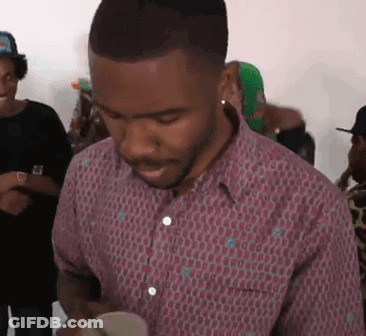 A Man In A Pink Shirt Is Standing In A Crowd Of People . GIF