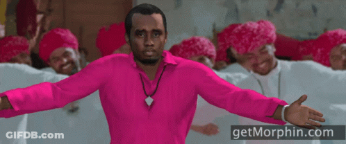 A Man In A Pink Shirt Is Standing In Front Of A Group Of Men Wearing Red Hats GIF