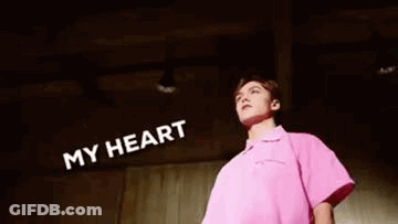 A Man In A Pink Shirt Is Standing In Front Of A Wall With Foam Coming Out Of His Mouth And Head . GIF