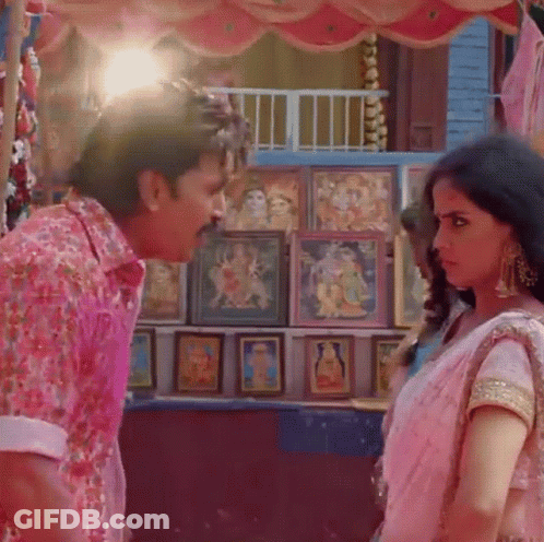 A Man In A Pink Shirt Is Standing Next To A Woman In A Pink Dress GIF
