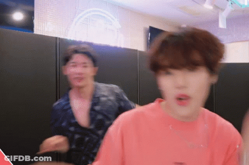 A Man In A Pink Shirt Is Standing Next To Another Man In A Black Shirt GIF