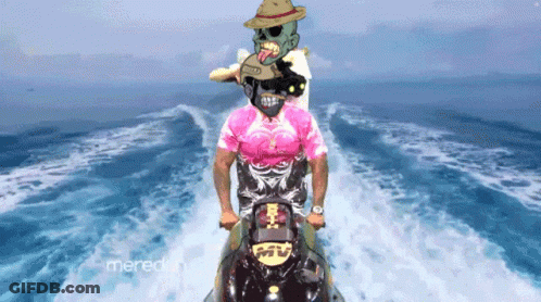 A Man In A Pink Shirt Rides A Jet Ski In The Ocean GIF