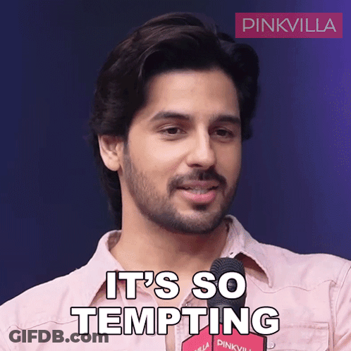 A Man In A Pink Shirt Says It 'S So Tempting In Front Of A Microphone GIF