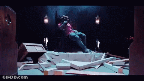 A Man In A Pink Shirt Sits On A Throne GIF