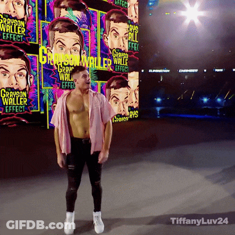 A Man In A Pink Shirt Stands In Front Of A Wall With Grayson Waller Effect Written On It GIF
