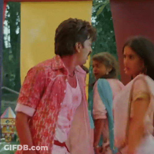 A Man In A Pink Shirt Talks To A Woman In A Pink Dress GIF