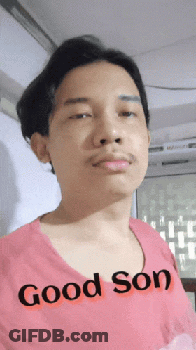 A Man In A Pink Shirt That Says Good Son GIF