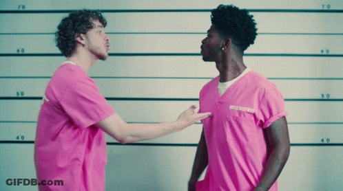 A Man In A Pink Shirt With A Tattoo On His Neck Stands Next To Another Man In A Pink Shirt GIF