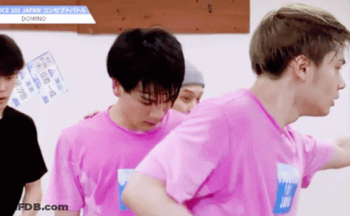 A Man In A Pink Shirt With The Word Domino On His Chest GIF