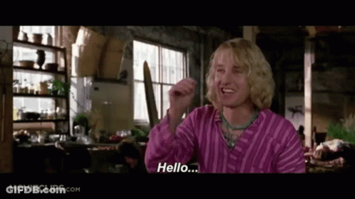 A Man In A Pink Striped Shirt Is Saying Hello .. GIF
