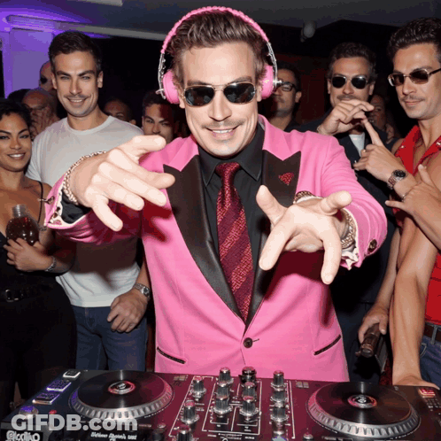 A Man In A Pink Suit And Headphones Is Playing Music On A Dj Mixer GIF