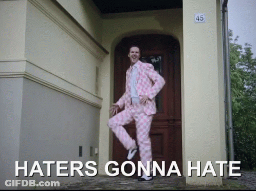 A Man In A Pink Suit Is Jumping In Front Of A Door That Says 45 On It GIF