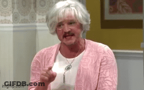 A Man In A Pink Sweater And Wig Is Holding A Piece Of Paper In His Hand . GIF