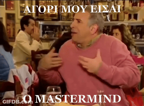 A Man In A Pink Sweater Is Sitting At A Table In Front Of A Sign That Says O Mastermind GIF