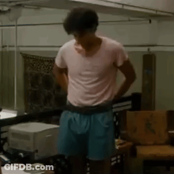 Man In Pink T-Shirt And Blue Shorts In Living Room GIF