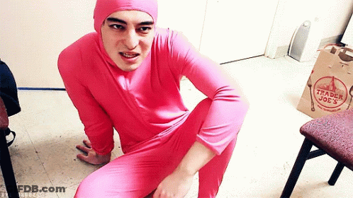 A Man In A Pink Trader Joe 'S Outfit Is Squatting On The Floor GIF