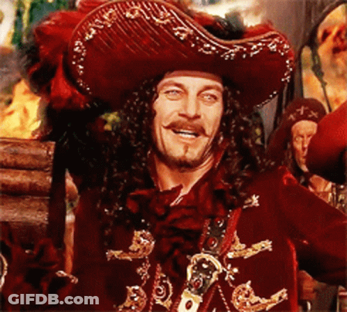 A Man In A Pirate Costume Is Smiling And Holding A Sword GIF