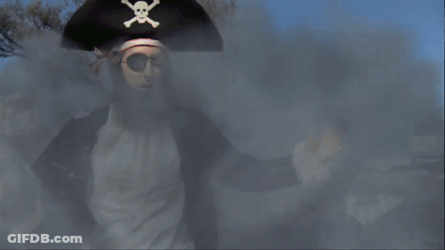 A Man In A Pirate Costume Is Standing In Front Of A Sign For Nickelodeon GIF
