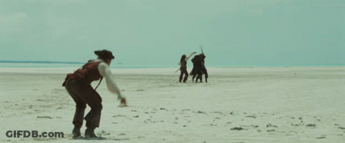 A Man In A Pirate Costume Is Walking On A Beach GIF