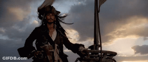A Man In A Pirate Costume Stands On A Boat GIF