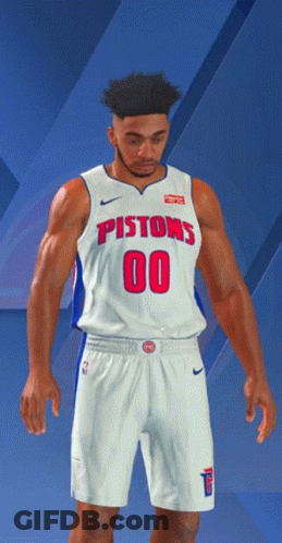 A Man In A Pistons Jersey And Shorts Stands In Front Of A Blue Background GIF