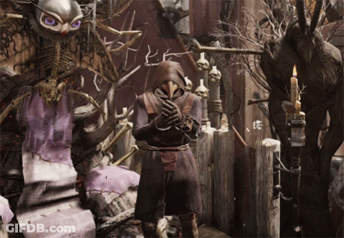 A Man In A Plague Doctor Costume Stands In Front Of A Skeleton GIF