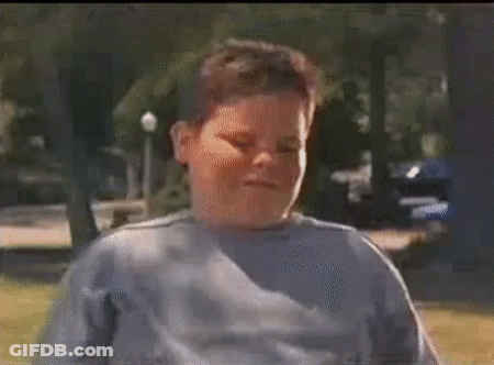 A Man In A Plaid Shirt And Red Pants Is Holding A Can Of Soda In His Hand . GIF