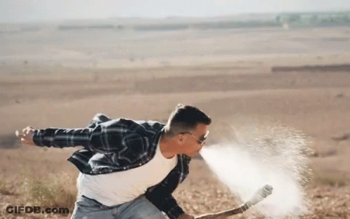 A Man In A Plaid Shirt And Sunglasses Is Throwing A Hammer In The Air GIF